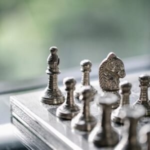 Metal chess pieces on board in room